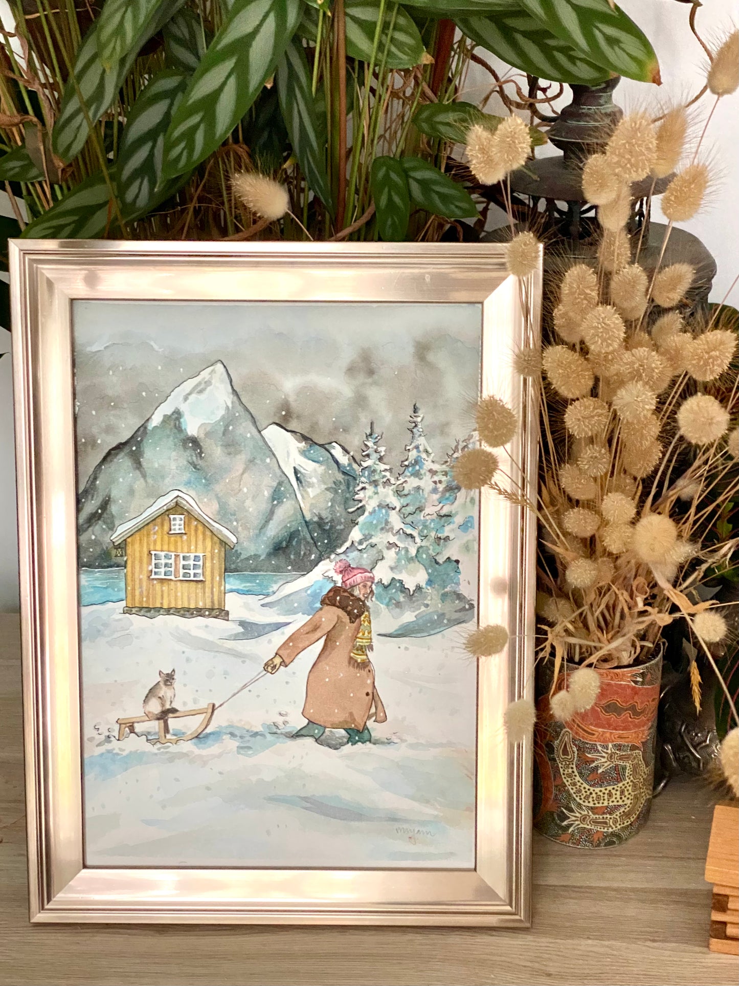 Through the snow - original watercolour painting of a girl pulling a Ragdoll cat on a sledge in the snow